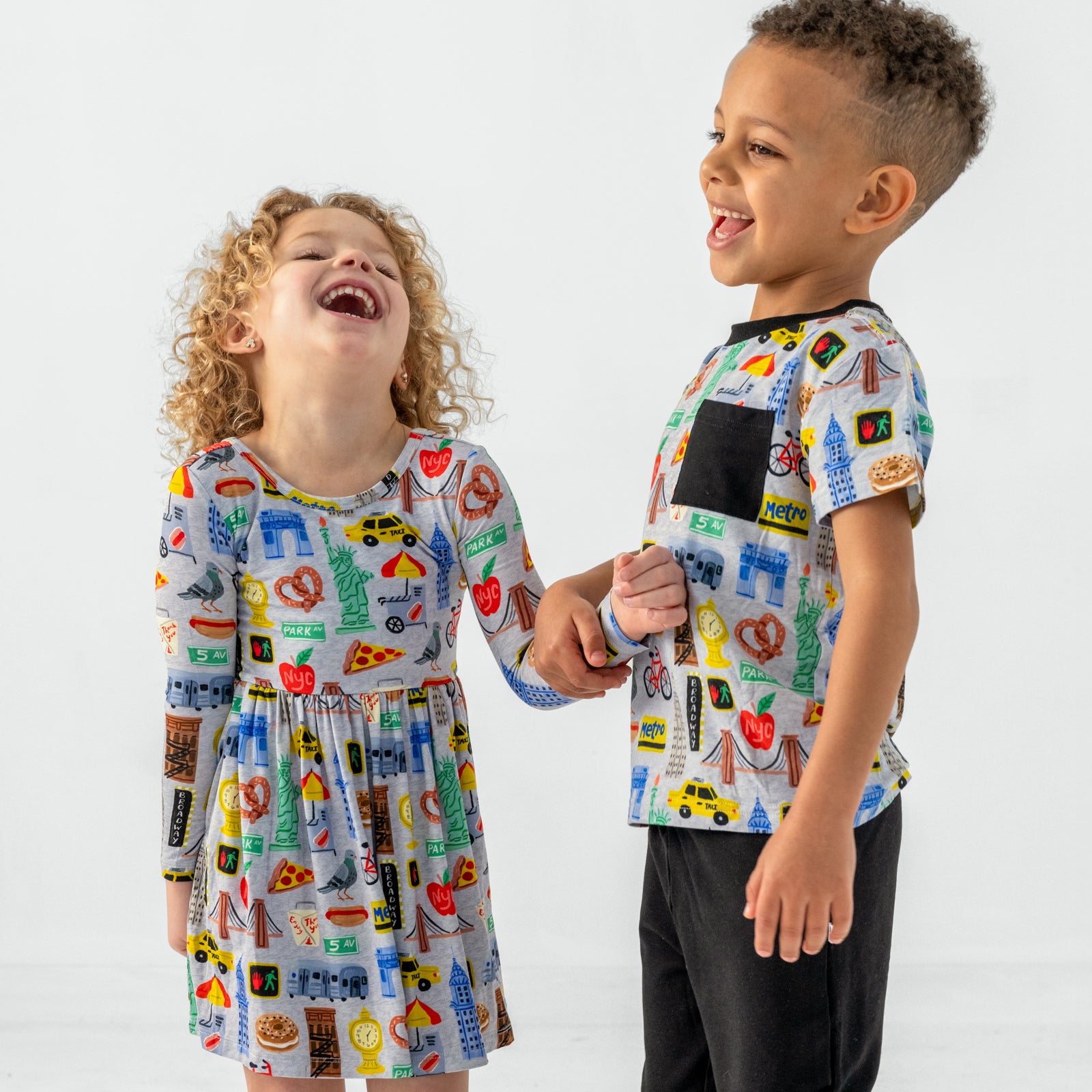 Two children wearing The Big Apple play styles