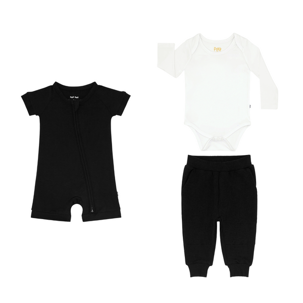 flat lay composite of a black shorty zippy, soft white bodysuit, and black jogger