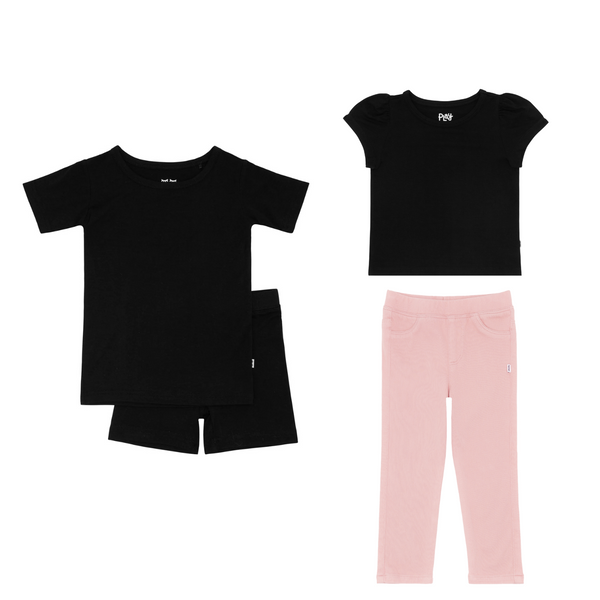 flat lay composite of a black two-piece short sleeve & shorts pajama set, black puff sleeve tee, and mauve blush denim jegging
