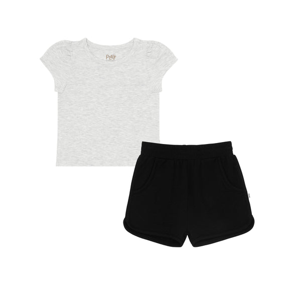 flat lay composite of a light heather gray puff sleeve tee and black dolphin shorts