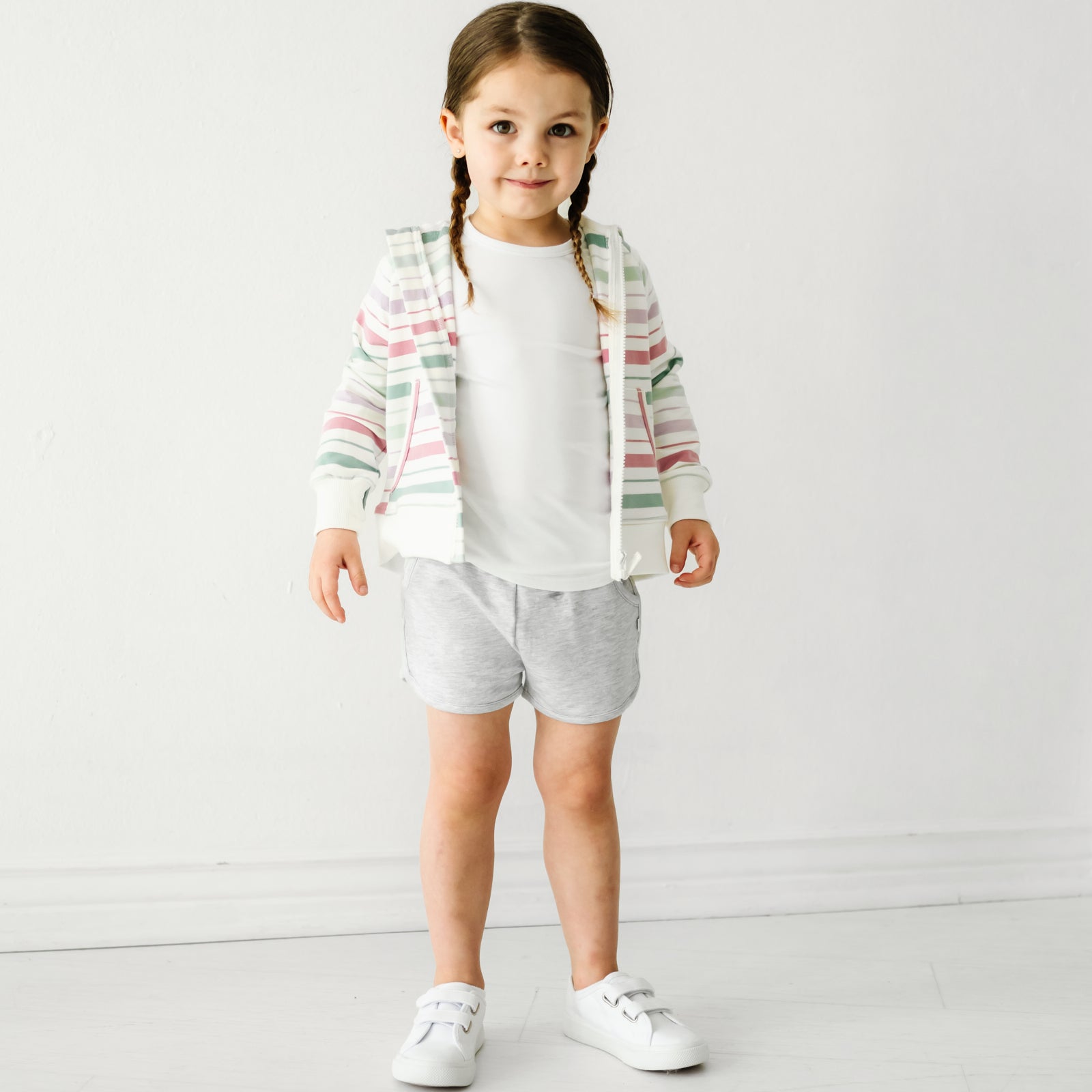 Child wearing Light Heather Gray dolphin shorts and coordinating Play top and zip hoodie