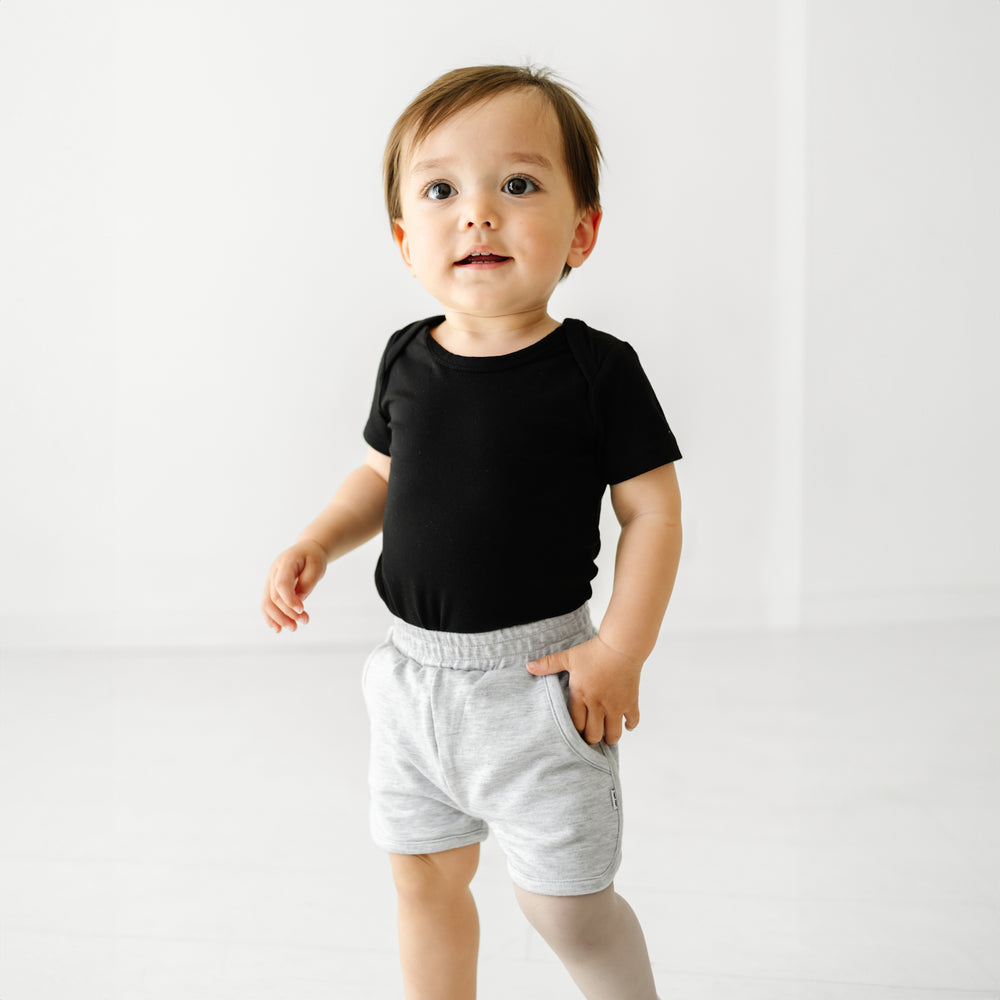 Child wearing a Black bodysuit and coordinating Play shorts