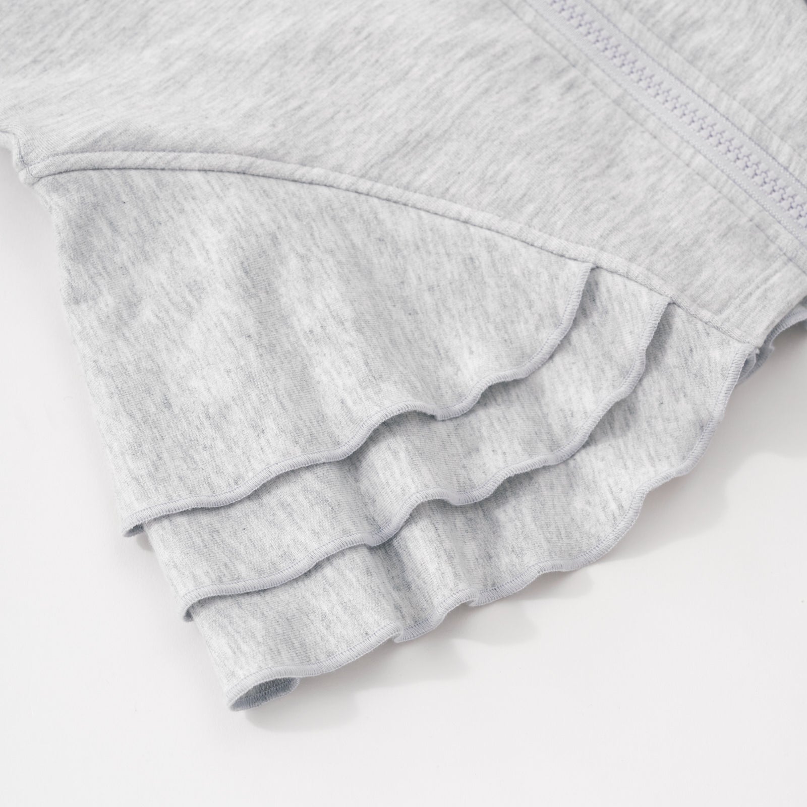 Close up flat lay image of the side peplum detail on the Light Heather Gray Peplum Hoodie