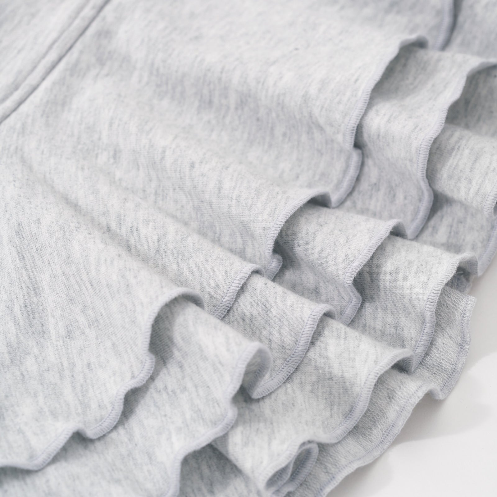 Alternative close up image of the peplum detail on the bottom of the Light Heather Gray Peplum Hoodie