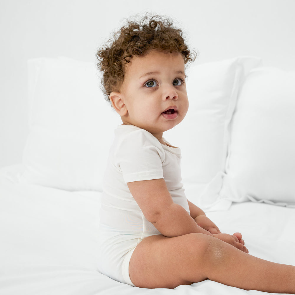 Alternate of sitting baby wearing the Soft White Bodysuit