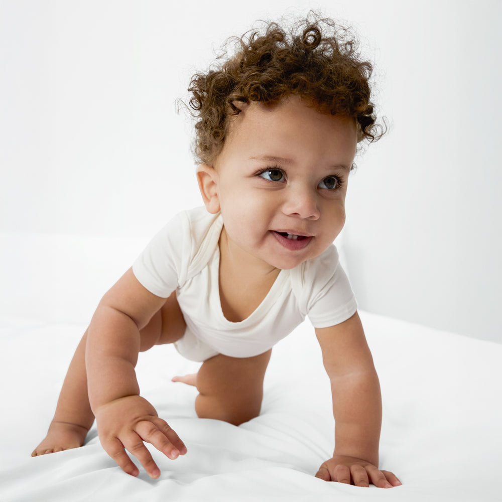 Crawling baby wearing the Soft White baby Bodysuit