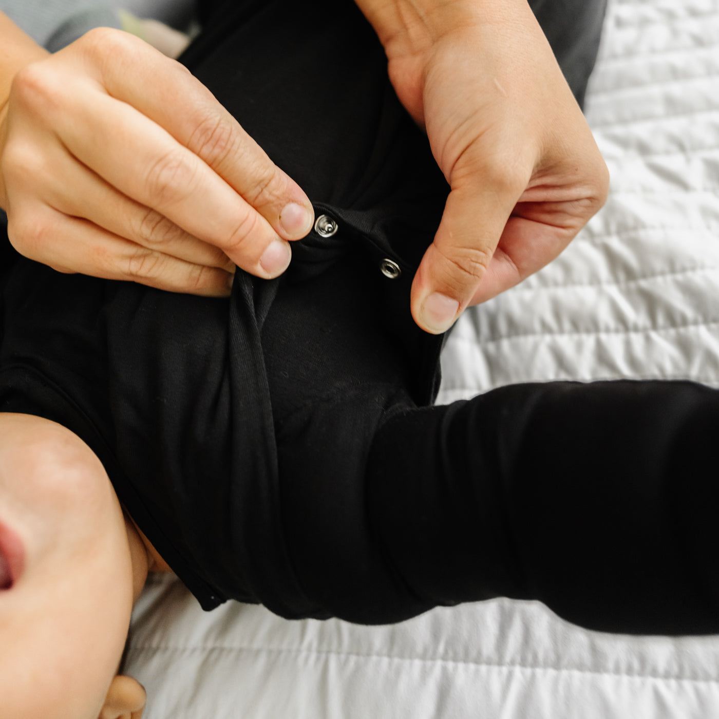 Alternate close up image of a child wearing a Black Sleepy Bag detailing the adjustable arm sleeve snaps