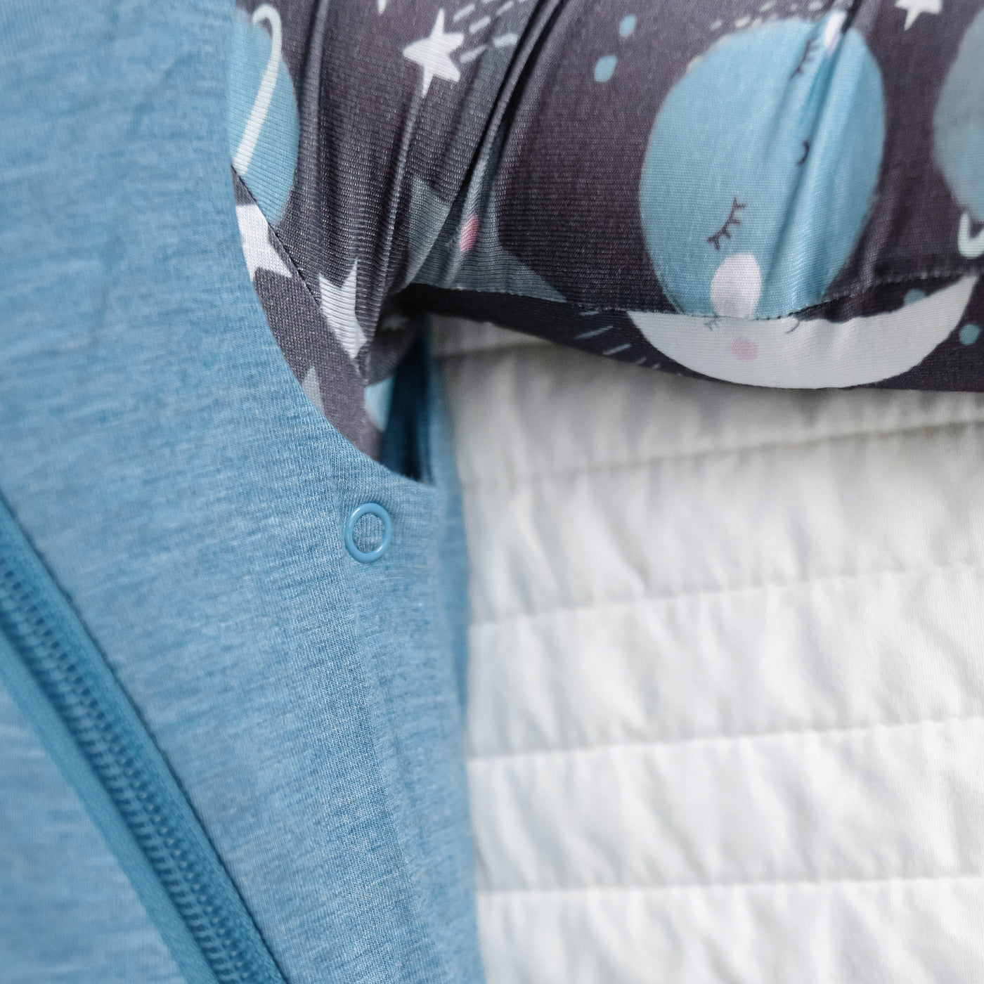 Alternate close up image of a child wearing a Heather Blue Sleepy Bag detailing the adjustable arm snaps